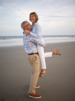 Image of Steve holding his wife on the beach